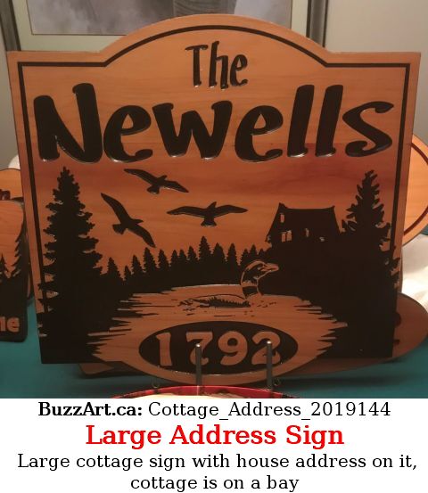 Large cottage sign with house address on it, cottage is on a bay